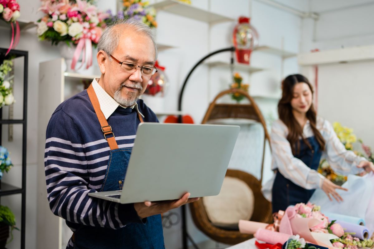 Portrait of mature male small business owner using laptop