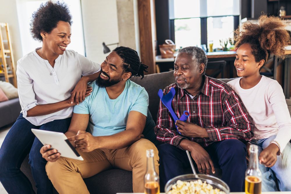 Family smiling and looking at each other sitting on a couch 
