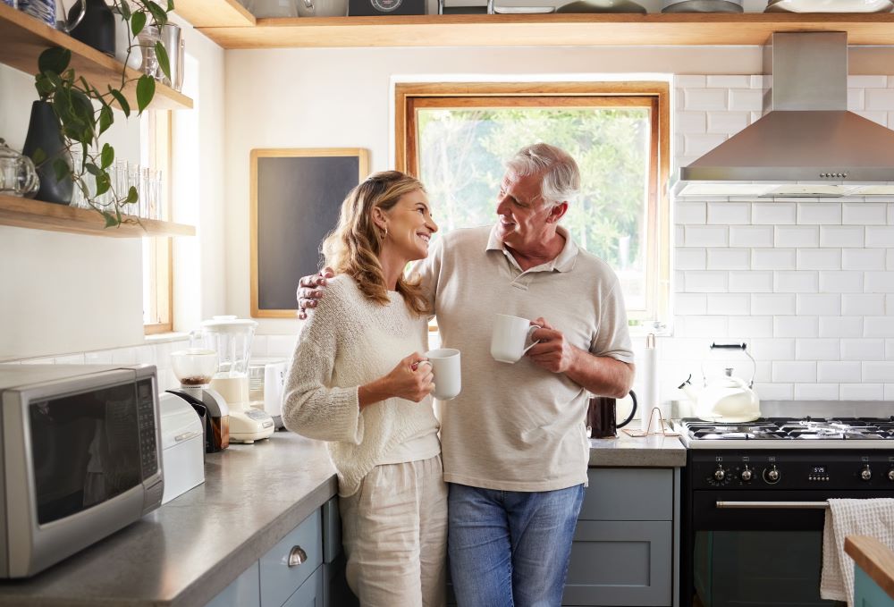 Retired couple having a coffee at their kitchen